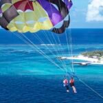parasailing, sobre el agua azul de maldivas, isla local de maafushi,