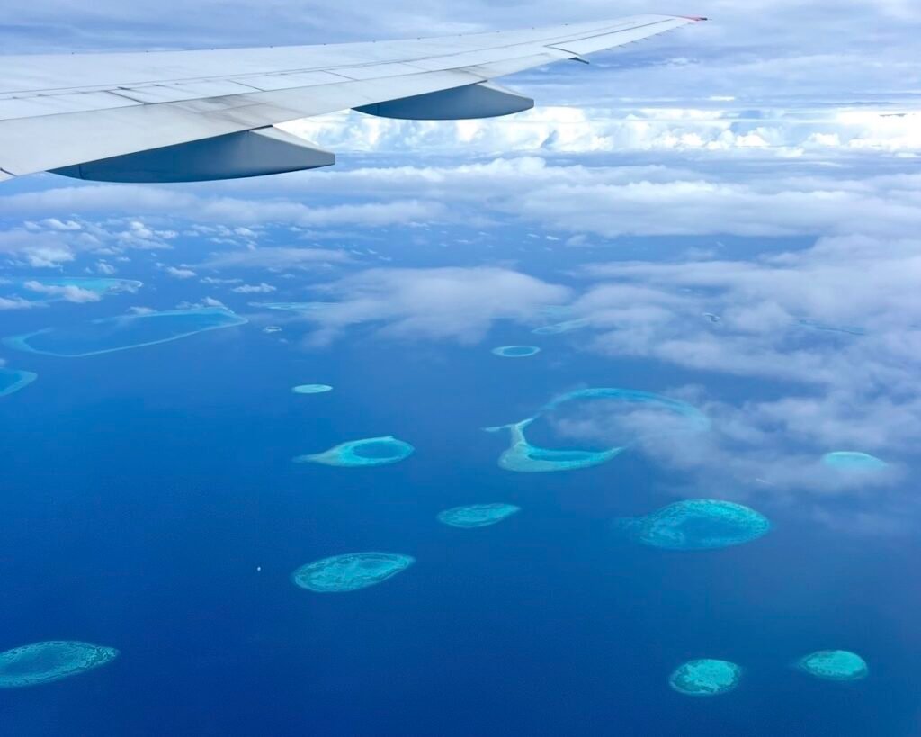 Vistas desde el avión llegando a las islas Maldivas, entre azules, azul turquesa, océano, mar, atolones, arrecifes